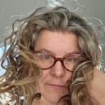 a  picture of Gwen, the fearless gardener, with curly hair and glasses